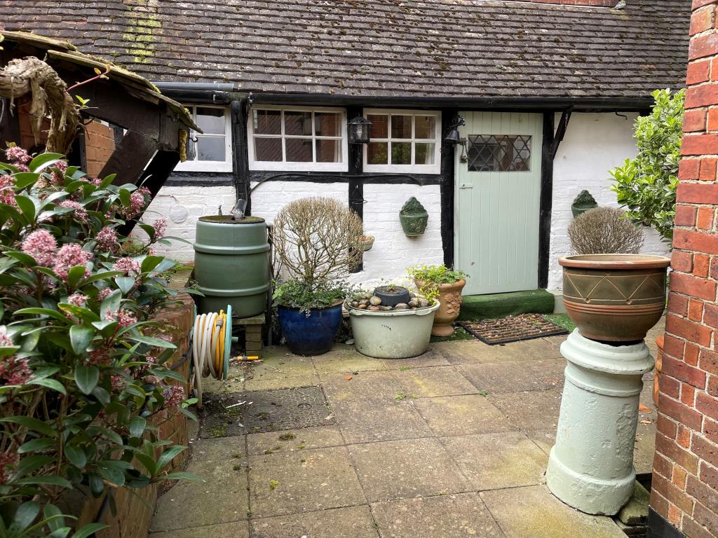 Lot: 10 - CHARACTER COTTAGE WITH GARAGE AND GARDENS - view of rear courtyard with patio area